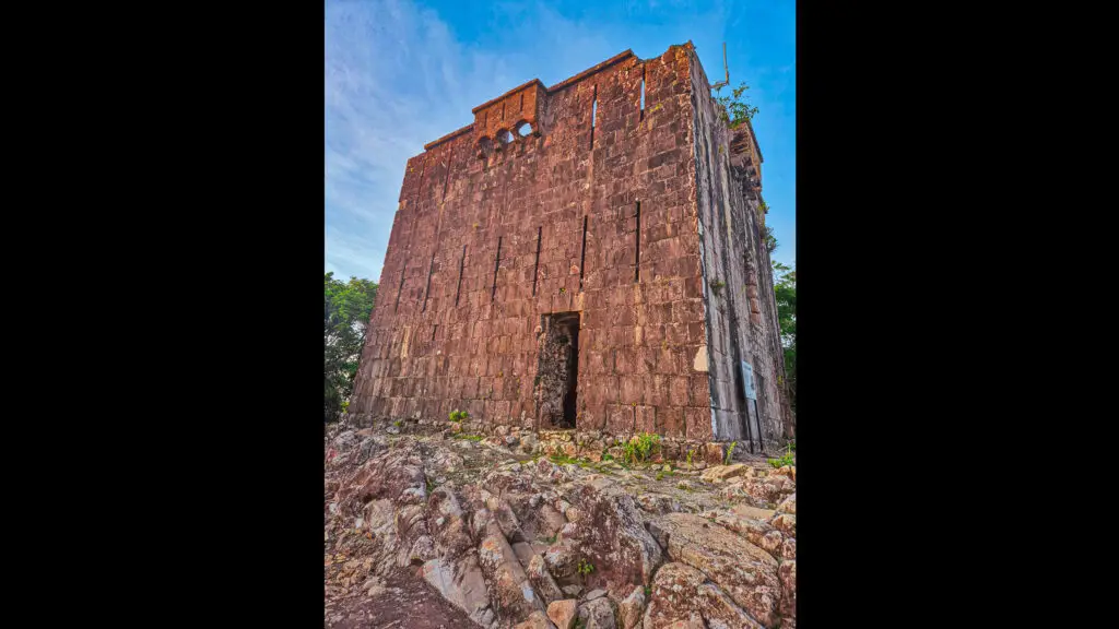 Tour de la Vigie à Terre-de-Haut, Les Saintes, construite en pierre, entourée de végétation et ciel dégagé