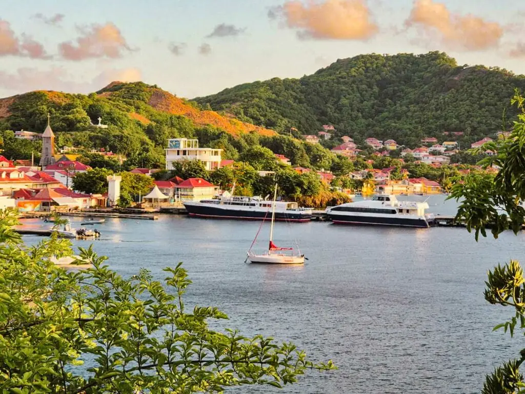 Quai d’embarquement à Terre-de-Haut, Les Saintes, avec voiliers, église en arrière-plan et mer turquoise