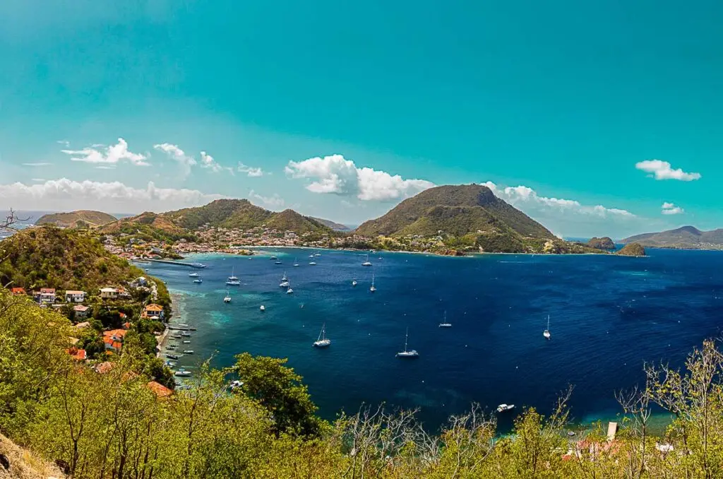 Vue panoramique sur la baie de Terre-de-Haut, Les Saintes, avec collines verdoyantes et voiliers sur mer turquoise