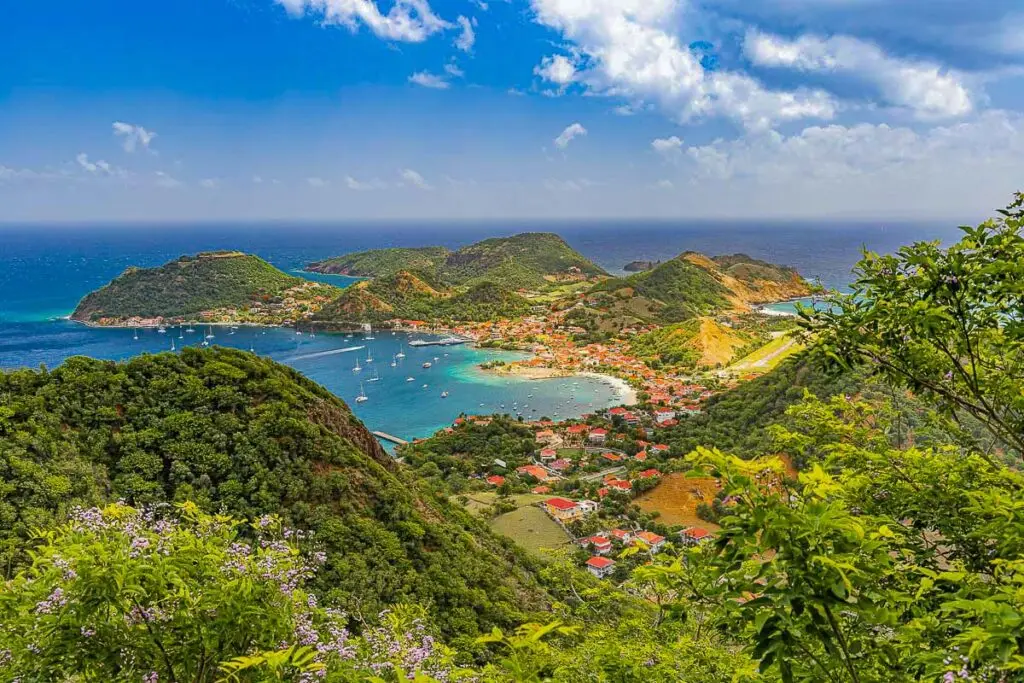 Vue panoramique sur Terre-de-Haut, Les Saintes, avec mer turquoise, collines verdoyantes et bateaux dans la baie